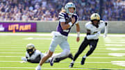 Sep 27, 2025; Manhattan, Kansas, USA; Kansas State Wildcats quarterback Avery Johnson (2) runs away from UCF Knights defensive back Phillip Dunnam (2) and UCF Knights defensive end Malchi Lawrence (51) during the second quarter at Bill Snyder Family Football Stadium. Mandatory Credit: Scott Sewell-Imagn Images