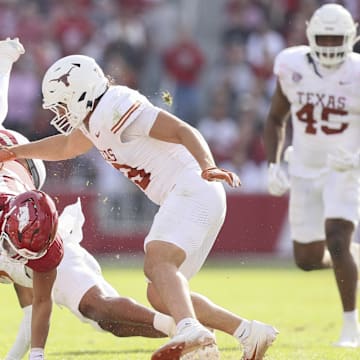 Nov 16, 2024; Fayetteville, Arkansas, USA; Arkansas Razorbacks quarterback Taylen Green (10) is tackled by Texas Longhorns defensive back Jaylon Guilbeau (3) as linebacker Liona Leaf (18) defends during the fourth quarter at Donald W. Reynolds Razorback Stadium. Texas won 20-10. Mandatory Credit: Nelson Chenault-Imagn Images