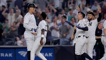 Jul 10, 2025; Bronx, New York, USA; New York Yankees designated hitter Aaron Judge (99) celebrates with second baseman Jazz Chisholm Jr. (13) and shortstop Anthony Volpe (11) and left fielder Jasson Dominguez (24) after his tenth inning walkoff sacrifice fly against the Seattle Mariners at Yankee Stadium. Mandatory Credit: Brad Penner-Imagn Images