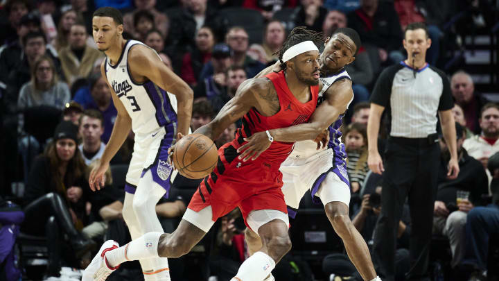 Dec 26, 2023; Portland, Oregon, USA; Sacramento Kings guard De'Aaron Fox (5) reaches in during the first half against Portland Trail Blazers forward Jerami Grant (9) at Moda Center. Mandatory Credit: Troy Wayrynen-USA TODAY Sports