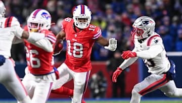 Dec 22, 2024; Orchard Park, New York, USA; Buffalo Bills wide receiver Amari Cooper (18) stiff arms New England Patriots linebacker Christian Elliss (53) in the second quarter at Highmark Stadium. Mandatory Credit: Mark Konezny-Imagn Images
