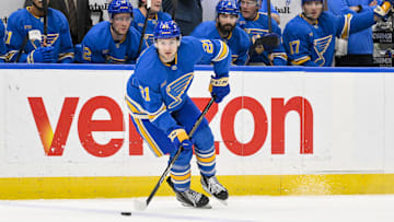 Apr 5, 2025; St. Louis, Missouri, USA;  St. Louis Blues right wing Jimmy Snuggerud (21) controls the puck against the Colorado Avalanche during the second period at Enterprise Center.