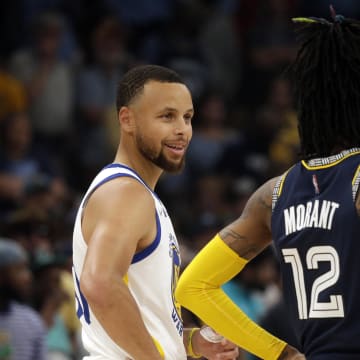 May 3, 2022; Memphis, Tennessee, USA; Golden State Warriors guard Stephen Curry (left) talks with Memphis Grizzlies guard Ja Morant (12) during a timeout in game two of the second round for the 2022 NBA playoffs at FedExForum. 