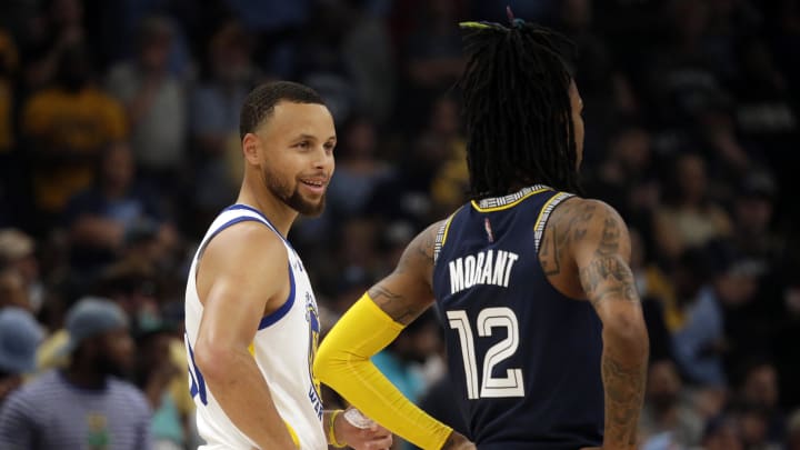 May 3, 2022; Memphis, Tennessee, USA; Golden State Warriors guard Stephen Curry (left) talks with Memphis Grizzlies guard Ja Morant (12) during a timeout in game two of the second round for the 2022 NBA playoffs at FedExForum. 