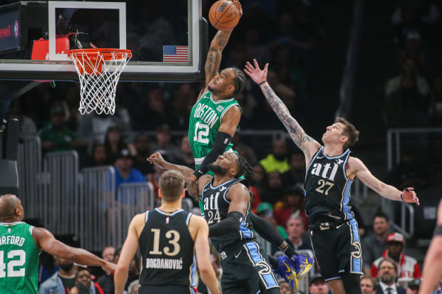 Boston Celtics forward Oshae Brissett (12) attempts a dunk vs. Bruno Fernando (24) and Vit Krejci of the Atlanta Hawks.