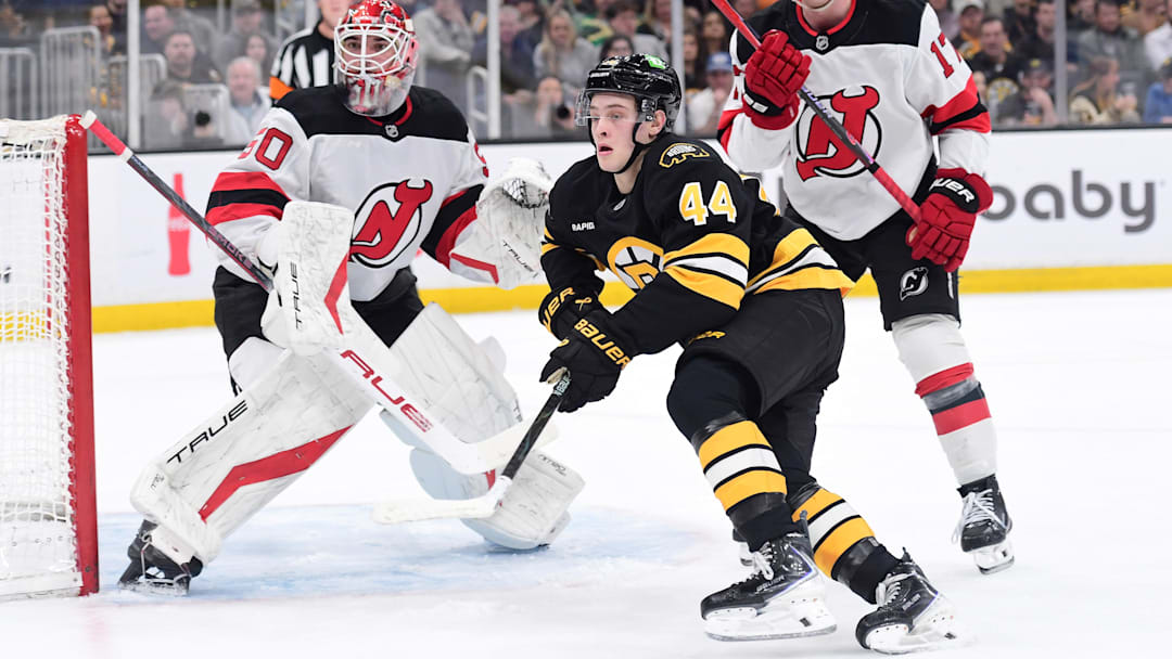 Apr 14, 2026; Boston, Massachusetts, USA; New Jersey Devils goalie Nico Daws (50) looks on as defenseman Simon Nemec (17) and Boston Bruins forward James Hagens (44) go after the puck during the first period at TD Garden. Mandatory Credit: Bob DeChiara-Imagn Images
