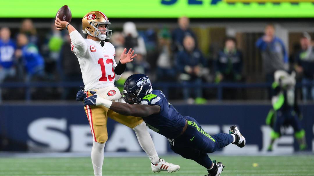 Jan 17, 2026; Seattle, WA, USA; San Francisco 49ers quarterback Brock Purdy (13) is pressured by Seattle Seahawks defensive end DeMarcus Lawrence (0) during the first half in an NFC Divisional Round game at Lumen Field. Mandatory Credit: Steven Bisig-Imagn Images Jan 17, 2026; Seattle, WA, USA; San Francisco 49ers quarterback Brock Purdy (13) is pressured by Seattle Seahawks defensive end DeMarcus Lawrence (0) during the first half in an NFC Divisional Round game at Lumen Field. Mandatory Credit: Steven Bisig-Imagn Images