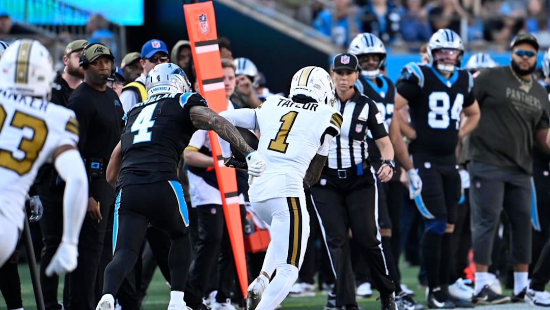 Nov 9, 2025; Charlotte, North Carolina, USA; New Orleans Saints cornerback Alontae Taylor (1) intercepts a pass as Carolina Panthers wide receiver Tetairoa McMillan (4) defends in the fourth quarter at Bank of America Stadium. Mandatory Credit: Bob Donnan-Imagn Images