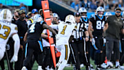 Nov 9, 2025; Charlotte, North Carolina, USA; New Orleans Saints cornerback Alontae Taylor (1) intercepts a pass as Carolina Panthers wide receiver Tetairoa McMillan (4) defends in the fourth quarter at Bank of America Stadium. Mandatory Credit: Bob Donnan-Imagn Images