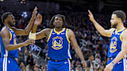 Jan 4, 2024; San Francisco, California, USA; Golden State Warriors forward Andrew Wiggins (22) and guard Kevon Looney (5) and guard Stephen Curry (30) react after drawing a foul against the Denver Nuggets during the first half at Chase Center. Mandatory Credit: John Hefti-Imagn Images