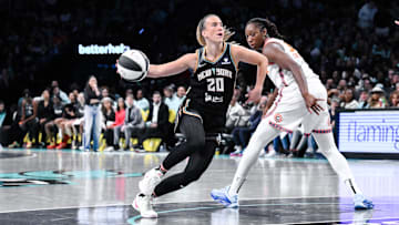 Jun 1, 2025; Brooklyn, New York, USA; New York Liberty guard Sabrina Ionescu (20) drives past Connecticut Sun center Tina Charles (31) during the second half at Barclays Center. Mandatory Credit: John Jones-Imagn Images
