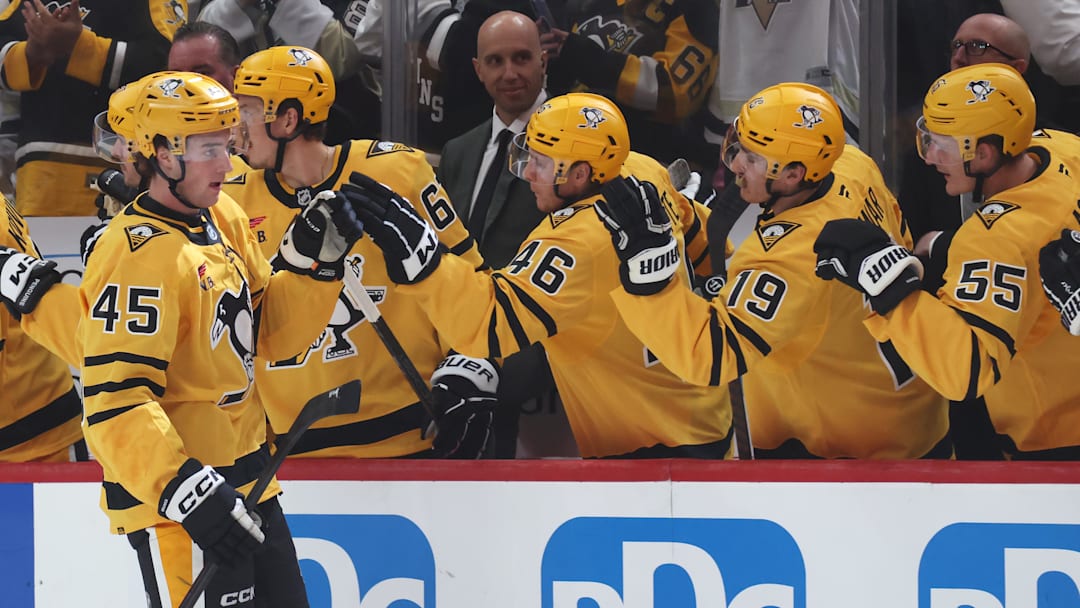 Oct 9, 2025; Pittsburgh, Pennsylvania, USA;  Pittsburgh Penguins defenseman Harrison Brunicke (45) celebrates his first NHL goal with the Penguins bench against the New York Islanders during the second period at PPG Paints Arena. Mandatory Credit: Charles LeClaire-Imagn Images