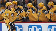 Oct 9, 2025; Pittsburgh, Pennsylvania, USA;  Pittsburgh Penguins defenseman Harrison Brunicke (45) celebrates his first NHL goal with the Penguins bench against the New York Islanders during the second period at PPG Paints Arena. Mandatory Credit: Charles LeClaire-Imagn Images