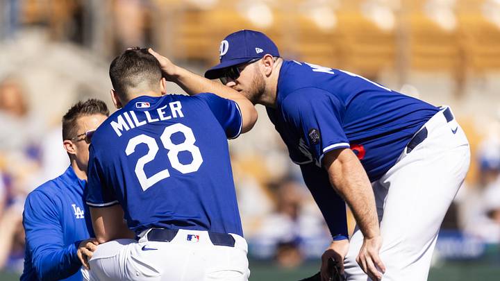 Feb 20, 2025; Phoenix, Arizona, USA; Los Angeles Dodgers pitcher Bobby Miller (28) talks to Max Muncy as he is tended to by a trainer after being hit in the head with a line drive against the Chicago Cubs during a spring training game at Camelback Ranch-Glendale. Mandatory Credit: Mark J. Rebilas-Imagn Images