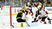 Apr 15, 2025; Boston, Massachusetts, USA;  New Jersey Devils center Dawson Mercer (91) deflects the puck past Boston Bruins goaltender Jeremy Swayman (1) while defenseman Nikita Zadorov (91) defends during the second period at TD Garden. Mandatory Credit: Bob DeChiara-Imagn Images