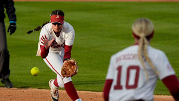 Feb 21, 2025; Tuscaloosa, Alabama, USA; Alabama second baseman Kali Heivilin snags a grounder and throws to first baseman Abby Duchscherer for an out against Virginia Tech during the Easton Bama Bash at Rhoads Stadium Friday in the home opener for the Crimson Tide.