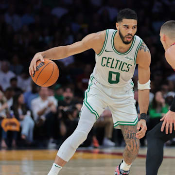 Mar 14, 2025; Miami, Florida, USA; Boston Celtics forward Jayson Tatum (0) dribbles the basketball as Miami Heat guard Tyler Herro (14) defends during the fourth quarter at Kaseya Center. Mandatory Credit: Sam Navarro-Imagn Images