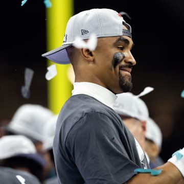 Philadelphia Eagles quarterback Jalen Hurts celebrates with the Vince Lombardi Trophy after defeating the Kansas City Chiefs during Super Bowl LIX.