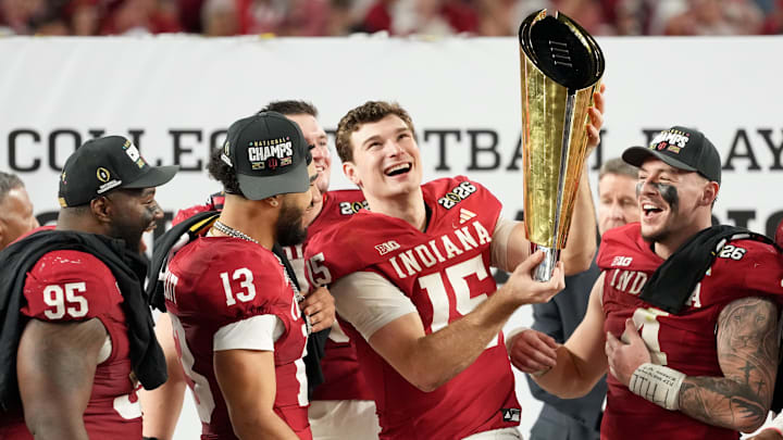 Jan 19, 2026; Miami Gardens, FL, USA; Indiana Hoosiers quarterback Fernando Mendoza (15) lifts the trophy after the College Football Playoff National Championship game against the Miami Hurricanes at Hard Rock Stadium. Mandatory Credit: Kirby Lee-Imagn Images
