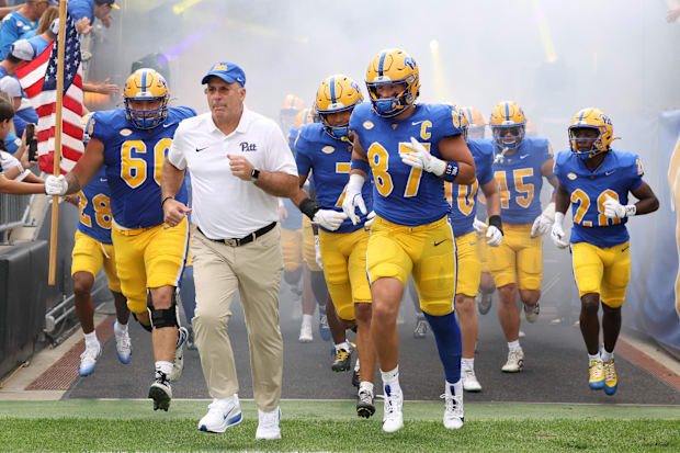 Pitt head coach Pat Narduzzi and tight end Jake Overman lead the team onto the field.