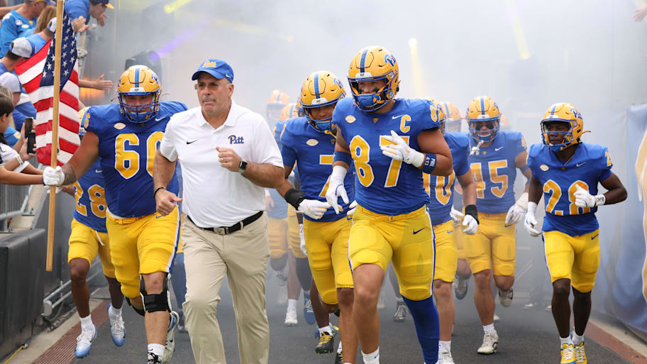 Pitt head coach Pat Narduzzi and tight end Jake Overman lead the team onto the field.