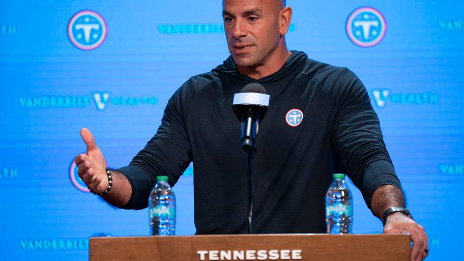 Robert Saleh speaks at a Titans podium.