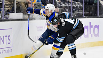 Jan 18, 2025; Salt Lake City, Utah, USA; St. Louis Blues right wing Alexey Toropchenko (13) battles with Utah Hockey Club defenseman Juuso Valimaki (4) for control of the puck during third period at the Delta Center. Mandatory Credit: Christopher Creveling-Imagn Images
