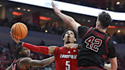 Mar 8, 2025; Louisville, Kentucky, USA;  Louisville Cardinals guard Terrence Edwards Jr. (5) shoots against Stanford Cardinal forward Maxime Raynaud (42) and forward Jaylen Thompson (24) during the second half at KFC Yum! Center. Louisville defeated Stanford 68-48. Mandatory Credit: Jamie Rhodes-Imagn Images