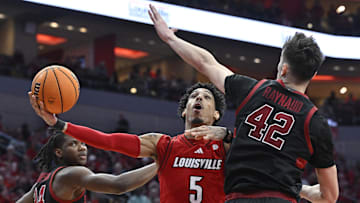 Mar 8, 2025; Louisville, Kentucky, USA;  Louisville Cardinals guard Terrence Edwards Jr. (5) shoots against Stanford Cardinal forward Maxime Raynaud (42) and forward Jaylen Thompson (24) during the second half at KFC Yum! Center. Louisville defeated Stanford 68-48. Mandatory Credit: Jamie Rhodes-Imagn Images