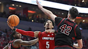 Mar 8, 2025; Louisville, Kentucky, USA;  Louisville Cardinals guard Terrence Edwards Jr. (5) shoots against Stanford Cardinal forward Maxime Raynaud (42) and forward Jaylen Thompson (24) during the second half at KFC Yum! Center. Louisville defeated Stanford 68-48. Mandatory Credit: Jamie Rhodes-Imagn Images
