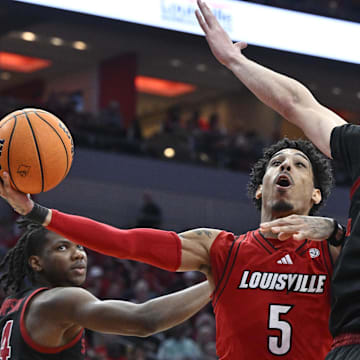 Mar 8, 2025; Louisville, Kentucky, USA;  Louisville Cardinals guard Terrence Edwards Jr. (5) shoots against Stanford Cardinal forward Maxime Raynaud (42) and forward Jaylen Thompson (24) during the second half at KFC Yum! Center. Louisville defeated Stanford 68-48. Mandatory Credit: Jamie Rhodes-Imagn Images