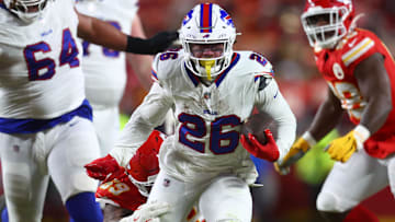 Jan 26, 2025; Kansas City, MO, USA; Buffalo Bills running back Ty Johnson (26) rushes the ball past Kansas City Chiefs defensive tackle Mike Pennel Jr. (69) during the second half in the AFC Championship game at GEHA Field at Arrowhead Stadium. 
