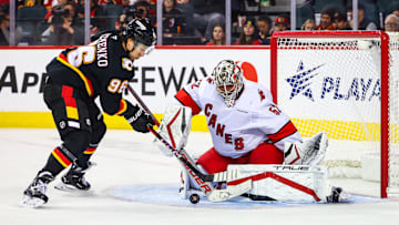 Oct 24, 2024; Calgary, Alberta, CAN; Carolina Hurricanes goaltender Pyotr Kochetkov (52) makes a save against Calgary Flames left wing Andrei Kuzmenko (96) during the third period at Scotiabank Saddledome. Mandatory Credit: Sergei Belski-Imagn Images