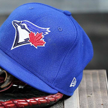 Apr 16, 2025; Toronto, Ontario, CAN; A Toronto Blue Jays hat and glove in the dugout during a game against the Atlanta Braves at Rogers Centre.