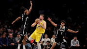 Mar 10, 2025; Brooklyn, New York, USA; Los Angeles Lakers guard Luka Doncic (77) looks to pass the ball against Brooklyn Nets forwards Ziaire Williams (8) and Cameron Johnson (2) during the fourth quarter at Barclays Center. Mandatory Credit: Brad Penner-Imagn Images