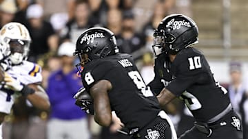 Oct 26, 2024; College Station, Texas, USA; Texas A&M Aggies quarterback Marcel Reed (10) hands off the ball to running back Le'Veon Moss (8) during the fourth quarter against the LSU Tigers. The Aggies defeated the Tigers 38-23; at Kyle Field. Mandatory Credit: Maria Lysaker-Imagn Images.  