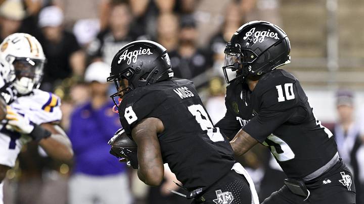 Oct 26, 2024; College Station, Texas, USA; Texas A&M Aggies quarterback Marcel Reed (10) hands off the ball to running back Le'Veon Moss (8) during the fourth quarter against the LSU Tigers. The Aggies defeated the Tigers 38-23; at Kyle Field. Mandatory Credit: Maria Lysaker-Imagn Images.  
