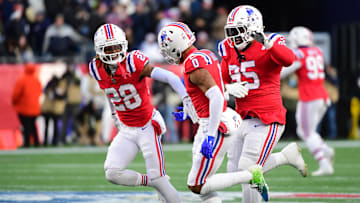 Dec 1, 2024; Foxborough, Massachusetts, USA;  New England Patriots cornerback Christian Gonzalez (0) is congratulated by defensive tackle Daniel Ekuale (95) and cornerback Alex Austin (28) after an interception during the second half against the Indianapolis Colts at Gillette Stadium. Mandatory Credit: Bob DeChiara-Imagn Images