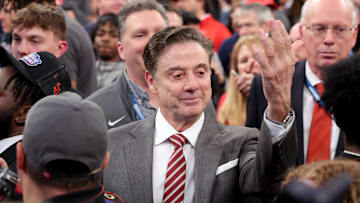  St. John's head coach Rick Pitino gestures towards campus minister for athletics Richard Rock to down the net after defeating the Creighton Bluejays to win the Big East Tournament at Madison Square Garden. 