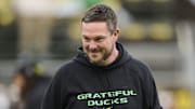 Oct 25, 2025; Eugene, Oregon, USA; Oregon Ducks head coach Dan Lanning encourages players during warm ups before a game against the Wisconsin Badgers at Autzen Stadium. The Ducks are wearing uniforms celebrating the Grateful Dead. Mandatory Credit: Troy Wayrynen-Imagn Images