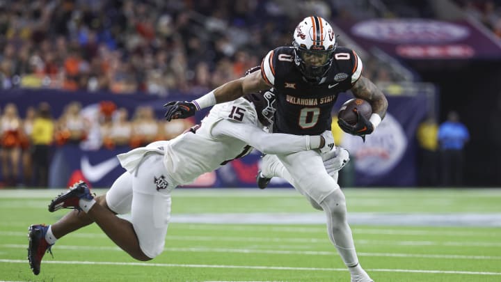 Dec 27, 2023; Houston, TX, USA; Oklahoma State Cowboys running back Ollie Gordon II (0) runs with the ball as Texas A&M Aggies defensive lineman Rylan Kennedy (15) attempts to make a tackle during the third quarter at NRG Stadium.