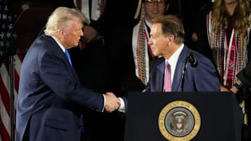 President Donald Trump shakes hands with legendary Alabama football coach Nick Saban
