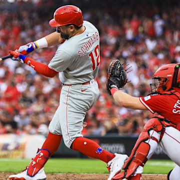 Aug 11, 2025; Cincinnati, Ohio, USA; Philadelphia Phillies designated hitter Kyle Schwarber (12) hits a two-run home run in the eighth inning against the Cincinnati Reds at Great American Ball Park. Mandatory Credit: Katie Stratman-Imagn Images