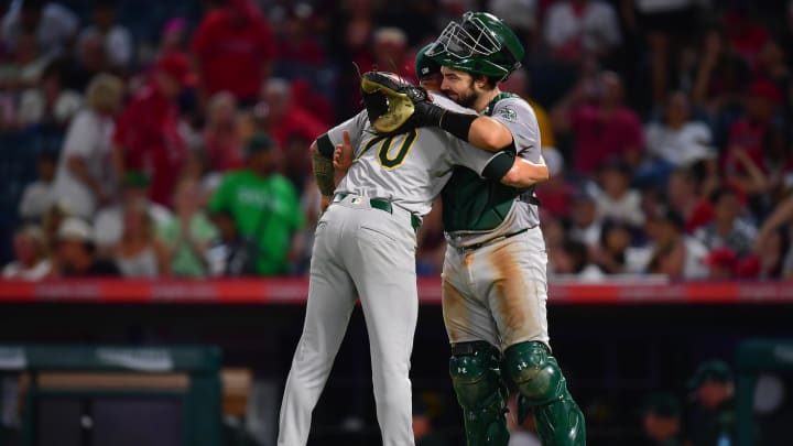 Jul 26, 2024; Anaheim, California, USA; Oakland Athletics pitcher Lucas Erceg (70) and catcher Shea Langeliers (23) celebrate the victory against the Los Angeles Angels at Angel Stadium. Mandatory Credit: Gary A. Vasquez-USA TODAY Sports