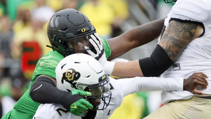 Sep 23, 2023; Eugene, Oregon, USA; Oregon Ducks defensive end Jordan Burch (1) sacks Colorado Buffaloes quarterback Shedeur Sanders (2) during the first half at Autzen Stadium.