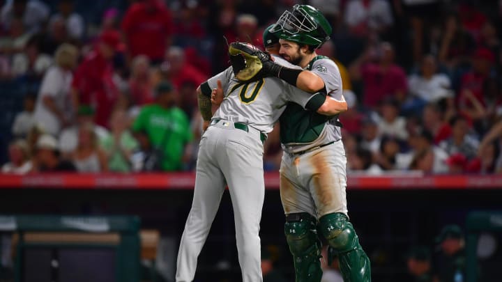 Jul 26, 2024; Anaheim, California, USA; Oakland Athletics pitcher Lucas Erceg (70) and catcher Shea Langeliers (23) celebrate the victory against the Los Angeles Angels at Angel Stadium. Mandatory Credit: Gary A. Vasquez-USA TODAY Sports