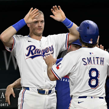 Aug 11, 2025; Arlington, Texas, USA; Texas Rangers third baseman Josh Jung (6) and left fielder Josh Smith (8) celebrates a run scored by Smith against the Arizona Diamondbacks during the sixth inning at Globe Life Field. 