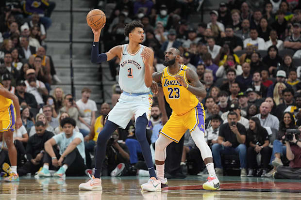 San Antonio Spurs center Victor Wembanyama (1) handles the ball in front of Los Angeles Lakers forward LeBron James (23).