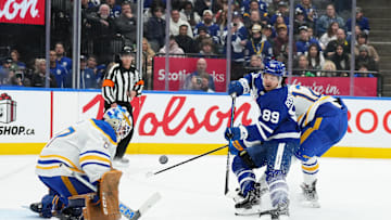 Dec 15, 2024; Toronto, Ontario, CAN; Toronto Maple Leafs left wing Nicholas Robertson (89) battles for the puck in front of the net with Buffalo Sabres left wing Jordan Greenway (12) during the third period at Scotiabank Arena. Mandatory Credit: Nick Turchiaro-Imagn Images