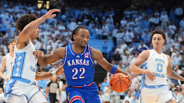 Nov 7, 2025; Chapel Hill, North Carolina, USA;  Kansas Jayhawks guard Darryn Peterson (22) with the ball as North Carolina Tar Heels guard Seth Trimble (7) and guard Kyan Evans (0) defend in the first half at Dean E. Smith Center. Mandatory Credit: Bob Donnan-Imagn Images